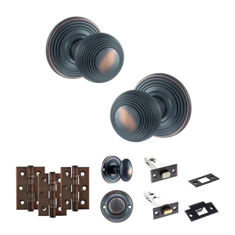 Pair of Ripon reeded beehive knobs in antique copper with hinges, thumbturn and bathroom deadbolt