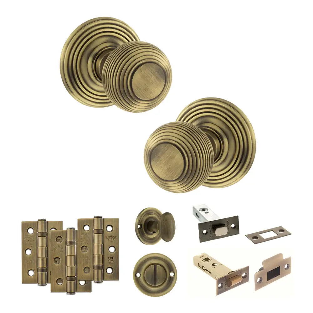 Pair of Ripon reeded beehive knobs in matt antique brass with hinges, thumbturn and deadbolt