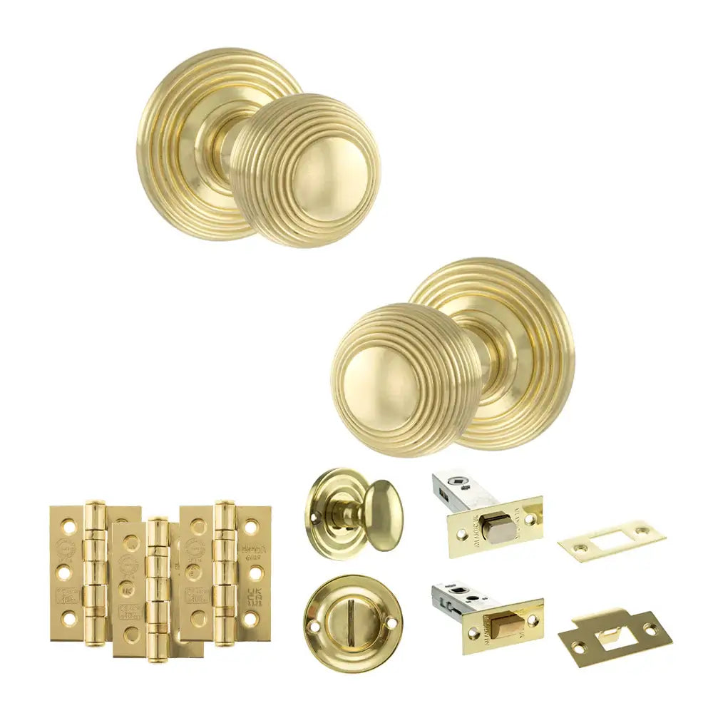 Pair of Ripon reeded beehive knobs in polished brass with hinges, thumbturn and bathroom deadbolt
