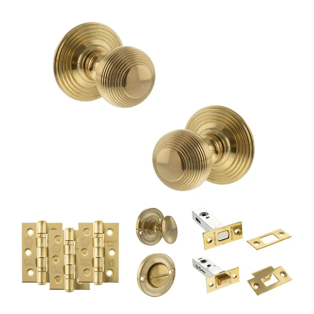 Pair of Ripon reeded beehive knobs in raw brass with hinges, thumbturn and bathroom deadbolt