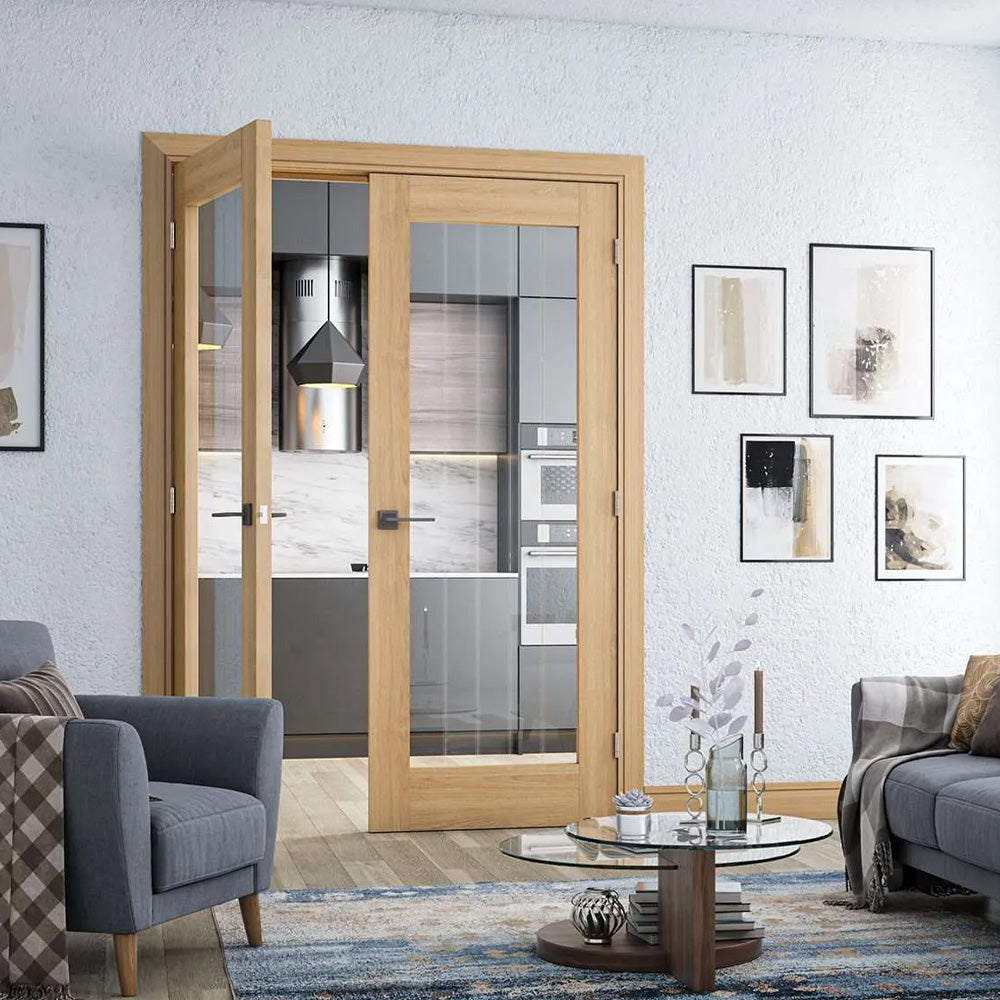 Living room with gray sofa, armchair, and coffee table, featuring a glass door leading to a kitchen.