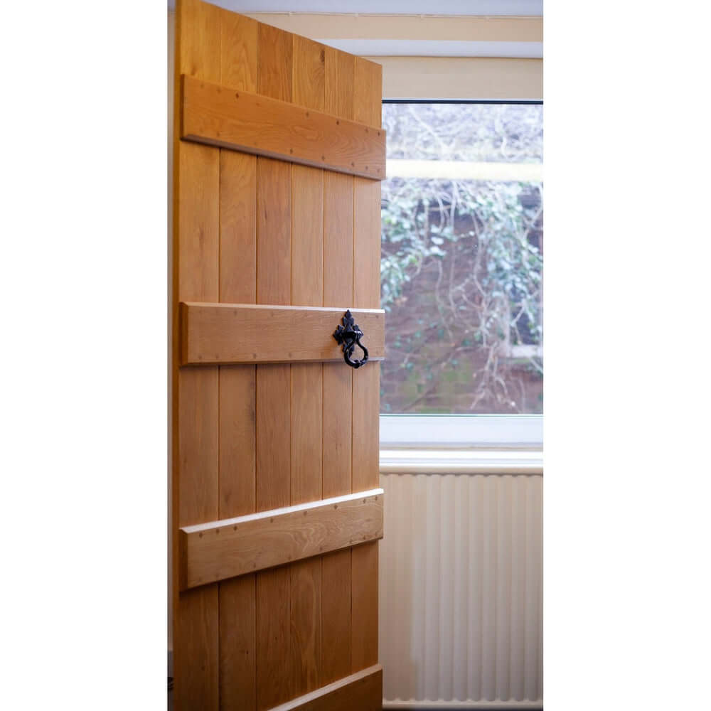 Lifestyle solid oak four-ledge barn door in a rustic interior
