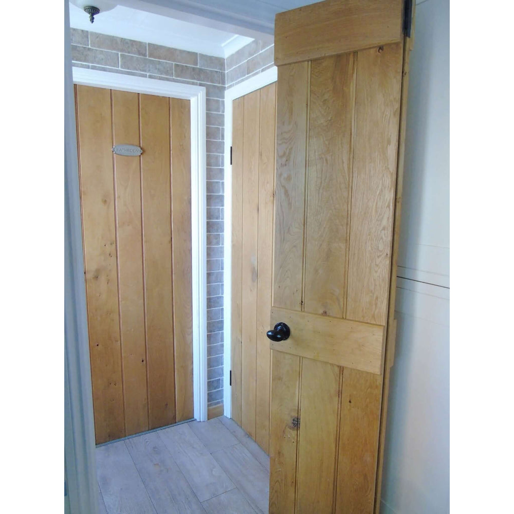 Lifestyle solid oak rustic bifold three-ledge bead and butt cottage door folded in an interior